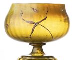 a yellow glass vase with a bird design on it