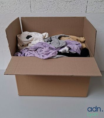 une boîte en carton contenant une pile de vêtements