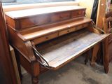 a wooden desk with a drawer underneath it in a room