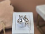 une boîte blanche posée sur une table, avec une bague à l'intérieur