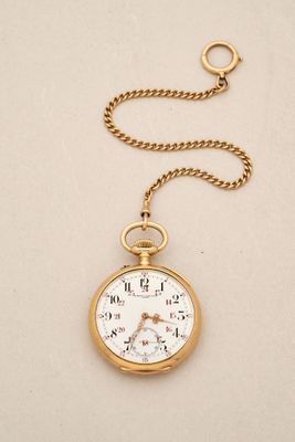 an old pocket watch with a chain hanging from it ' s side