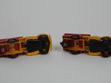 two toy trains that are sitting on a white surface