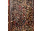 an old book with a brown cover and a red and black design