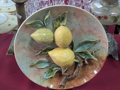 une assiette posée sur une table, sur laquelle se trouvent trois citrons