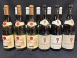 six bouteilles de vin sont alignées sur une table
