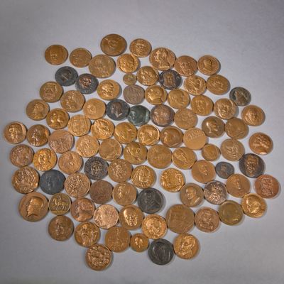 un tas de pièces d'or et d'argent posées sur une surface blanche