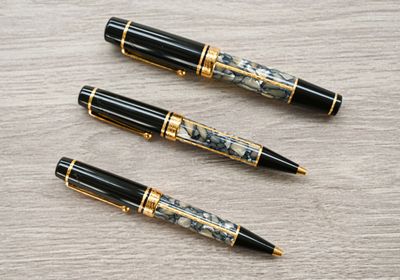 trois stylos posés les uns à côté des autres sur une table en bois