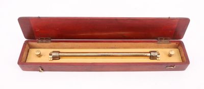 un vieux coffret en bois contenant une barre en laiton