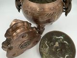 an antique bronze bowl with a lid and a small bowl with a lid