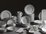 beaucoup d'assiettes et de bols blancs sur la table