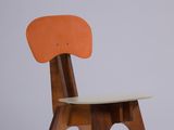 an image of a wooden chair with an orange seat on a white surface