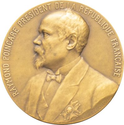 médaille d'or représentant le portrait d'un homme en costume et nœud papillon
