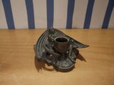 candlestick holder with a bat design on it on a wooden table