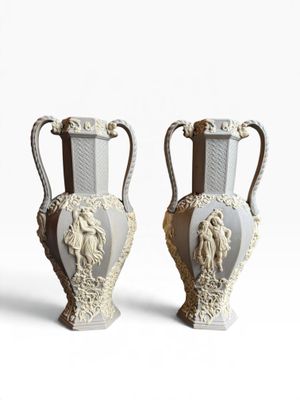 two vases that are sitting side by side on a white surface