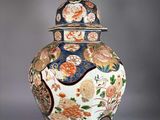 a large vase with a lid that has flowers on it