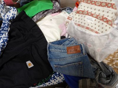 une pile de vêtements posée sur un lit