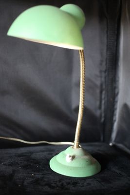 une lampe verte posée sur une surface noire