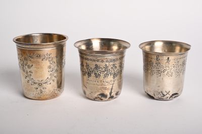 trois coupes en argent sont alignées sur une surface blanche