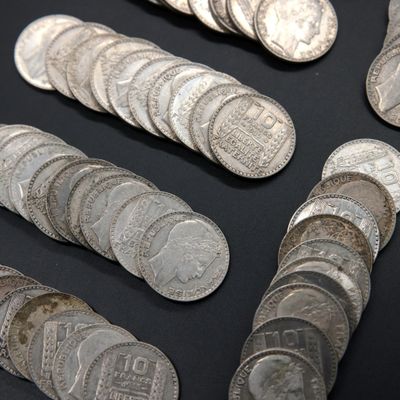 several silver coins are arranged in a row on a black surface