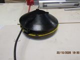 a black object on a table with a red handle
