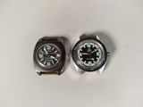 two watches that are sitting on a white surface