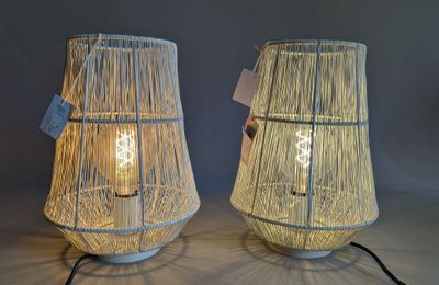 pair of white bamboo lamps on a table with a black cord