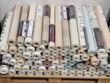 de nombreux rouleaux de tissu posés sur une palette en bois
