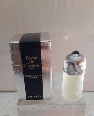 un flacon de parfum posé sur une table à côté d'une boîte