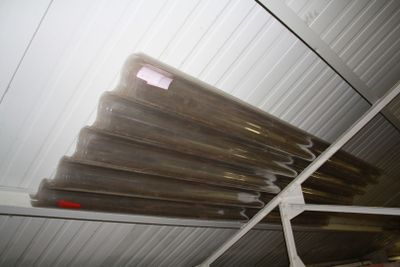 many rolls of plastic sitting on a rack in a room