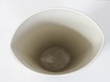 a white cup with a brown substance inside of it