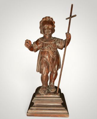 statue of a boy with a staff and a cross