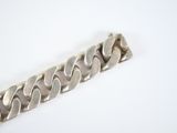 a close up of a silver bracelet on a white surface