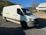 la camionnette blanche est garée dans un parking près d'un bâtiment