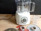 a blender sitting on top of a wooden table next to a pair of scissors
