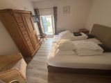 a bedroom with a bed, dresser, and a chair in it