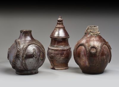trois vases marron posés les uns à côté des autres sur une table