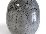 a gray vase that is sitting on a white surface