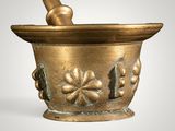 a gold mortar and a pestula on a white background