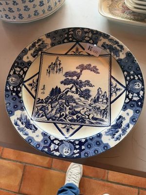 a blue and white plate with a picture of a landscape on it
