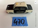 une petite voiture de police en jouet posée à côté d'une feuille de papier sur une table