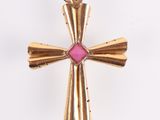 an image of a gold cross with a pink stone in the center