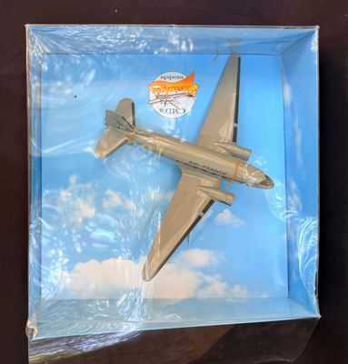 un petit avion en jouet qui se trouve dans une boîte posée sur une table