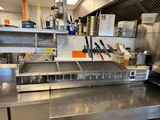 stainless steel counter top in a commercial kitchen with lots of utensils