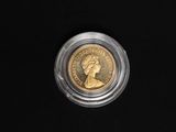 a close up of a coin in a clear plastic container on a black surface