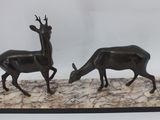 pair of bronze sculptures of deer and antelope on a marble base