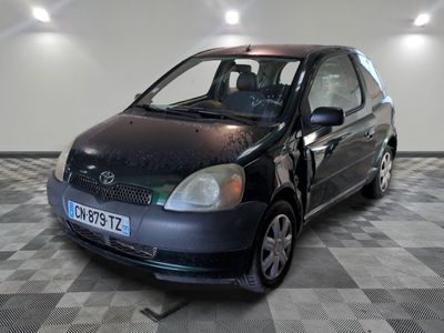 a small black car parked in a room with checkered flooring