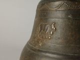 a metal bell with a wooden handle on a white surface