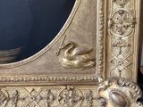 a gold frame with a painting of a man and a woman