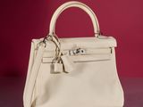 the small white purse is sitting on a table
