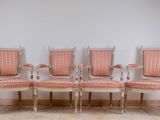 four chairs are lined up against a white wall in a room
